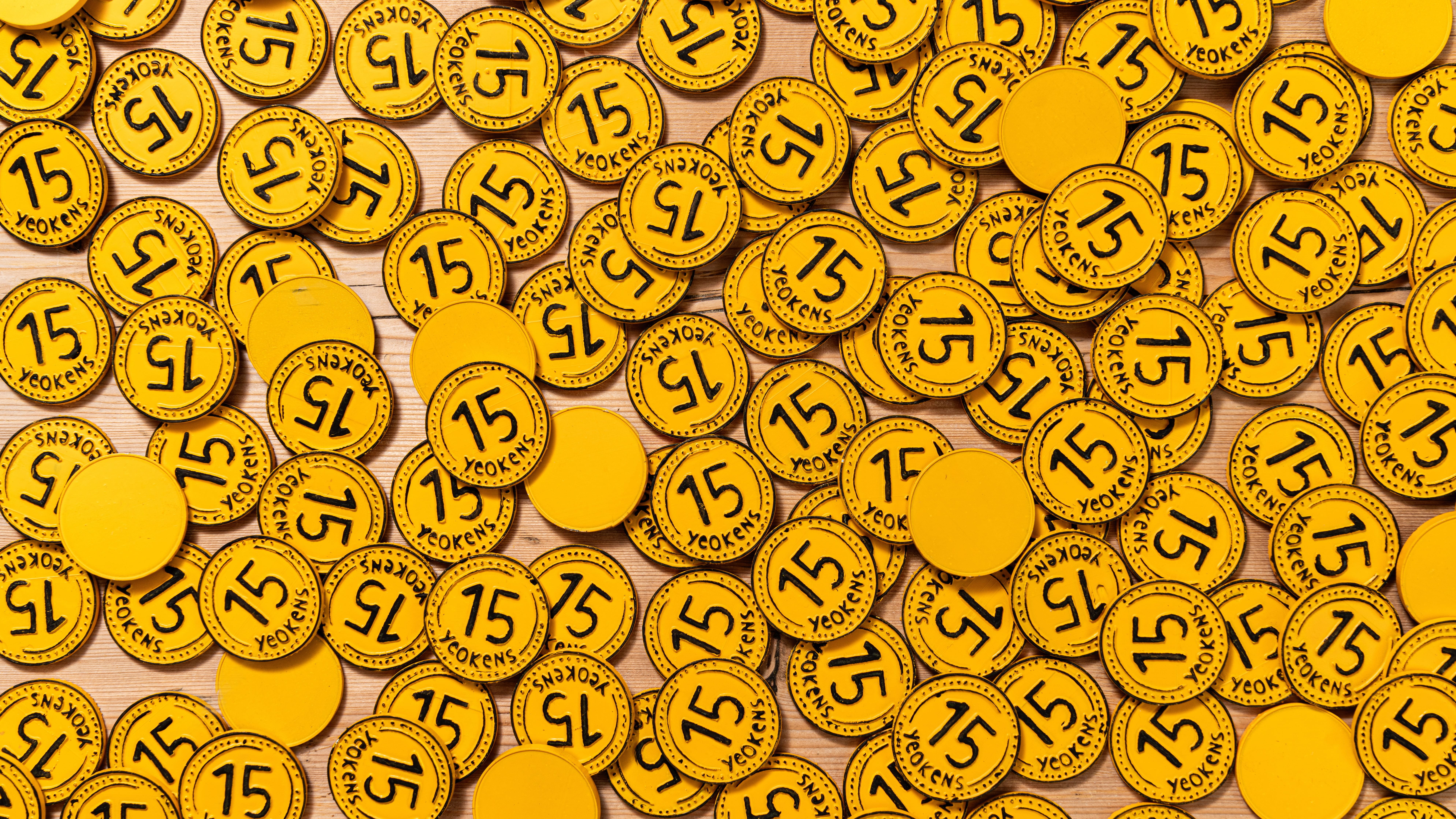 Yeo Valley Organic brand yoghurt. The cup is red with simplistic strawberries and text that reads 'Strawberry - creamy bio live yoghurt'. The yoghurt cup is on a rustic countertop alongside strawberries and a clear glass jar of granola, a spoon is visible on the left side